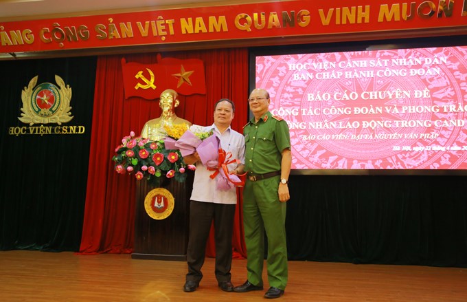 Thiếu tướng Trần Minh Chất tặng hoa Đại tá Nguyễn Văn Pháp - báo cáo viên của chương trình.
